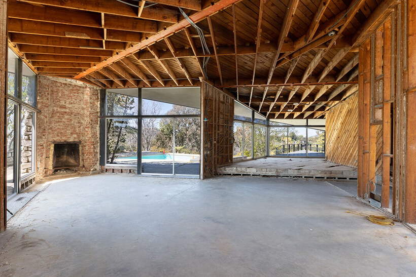 A down to the studs interior with a brick fireplace.