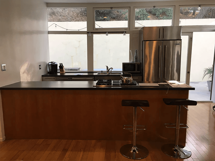 The kitchen, stools, and fridge