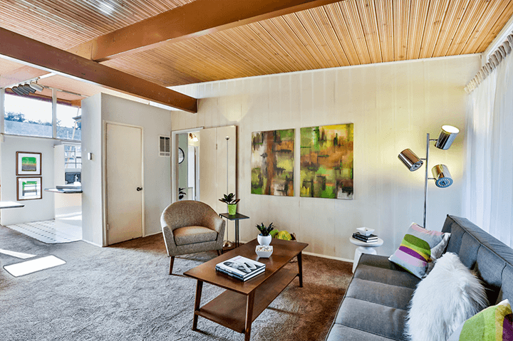 The living room of the Hollywood Riviera complex with a wooden ceiling and painting