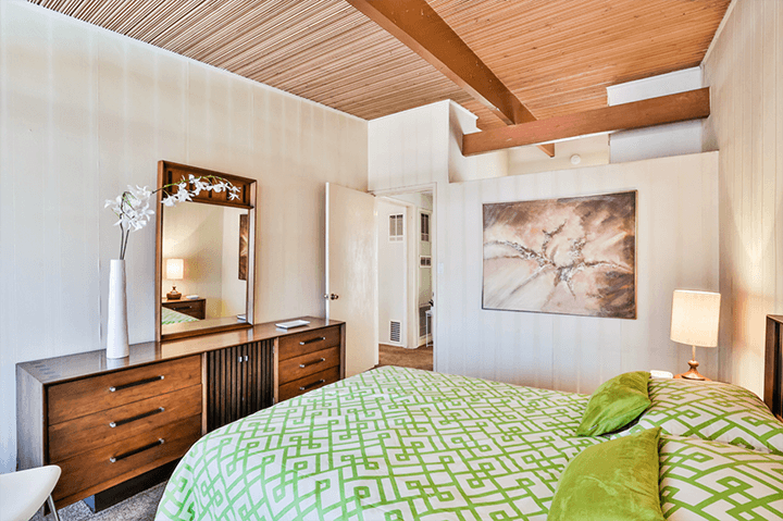 Bedroom with wooden ceiling and a mirror 