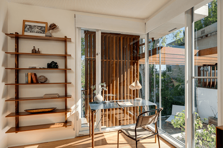 The workspace of the Thomas House has a wooden rack and a large glass window
