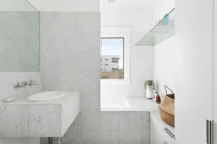 The bathroom is covered with white marble tiles