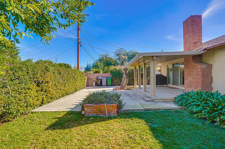 The backyard of 50s ranch style home in West Hills with grass