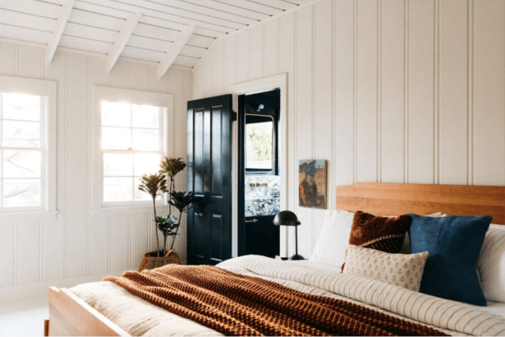 Bedroom with a black wardrobe and wooden ceiling and also has a window