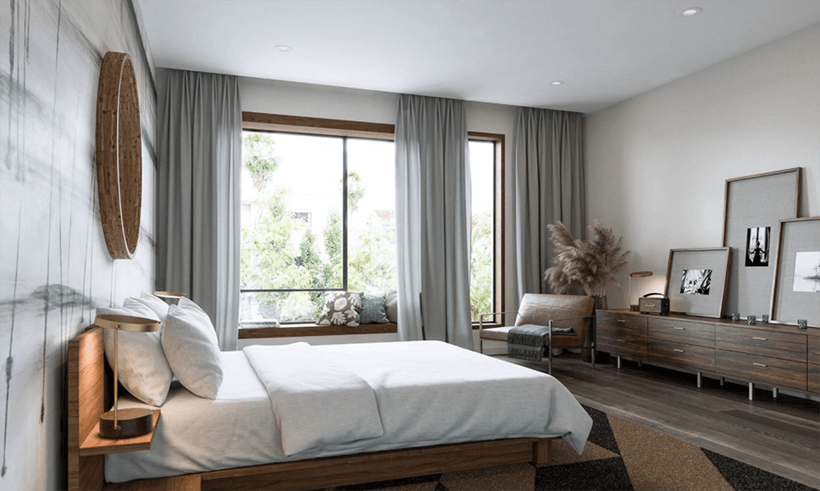 Serene bedroom with a large window capturing leafy green views.