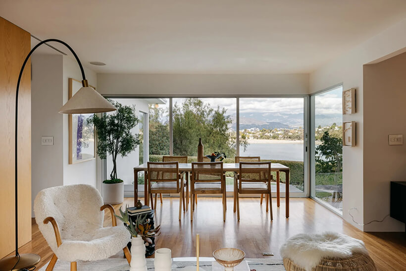 The dining table sits in front of large sliding doors, capturing postcard views of the Silver Lake Reservoir.
