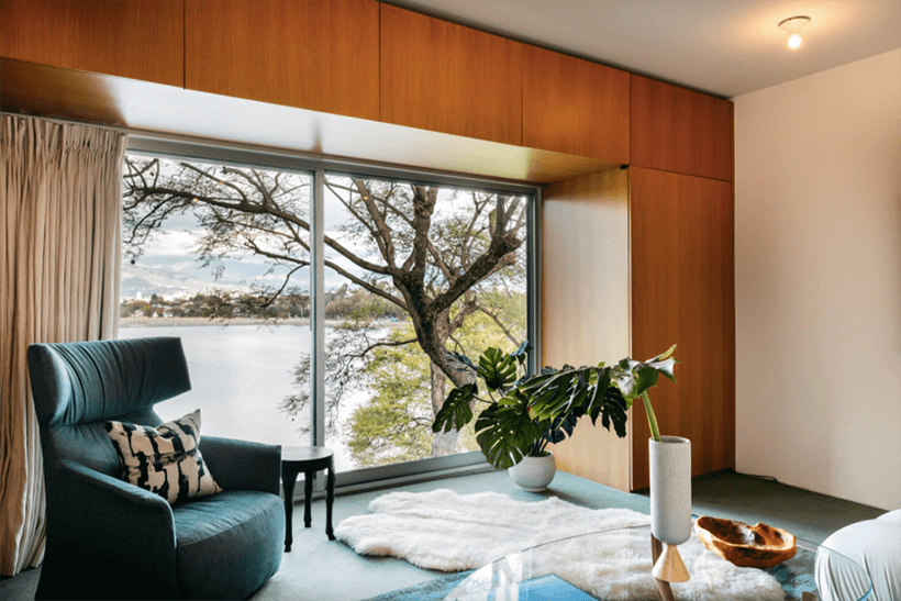 Large window surrounded by wood built-ins captures views of the Silver Lake reservoir.